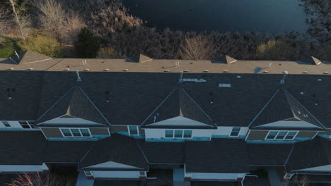 Aerial-top-down,-lakeside-townhouse-complex-with-a-gray-roof