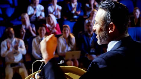 caucasian businessman speaking in business seminar on stage in auditorium 4k