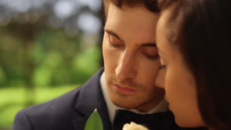 Candid-bride-and-groom-expressing-tenderness-outdoors.-Couple-posing-in-garden