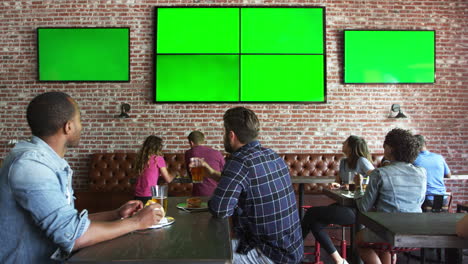 friends watching game in sports bar on screens shot on r3d