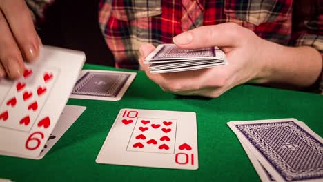 Close-up-of-female-hands-holding-cards-and-playing-solitaire