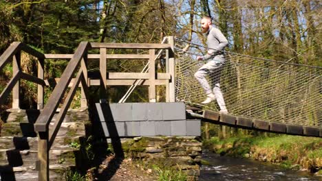 man running along and off a low hanging bridge