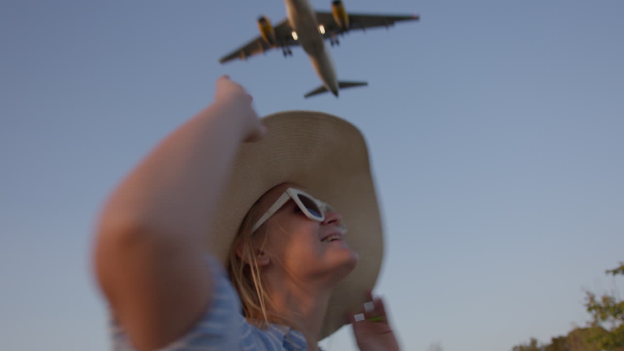 mujer con sombrero sonriendo en el avión de aterrizaje
