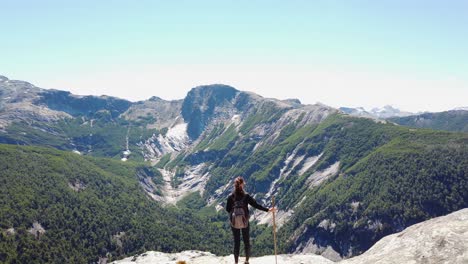 Pan-across-Patagonian-Andes-mountain-scene-with-young-female-hiker