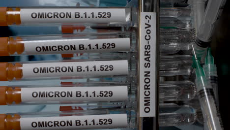 a close up vertical video of a medical professional wearing surgical gloves removing test tubes containing omicron samples from a laboratory rack, the latest strain of covid 19 found in south africa