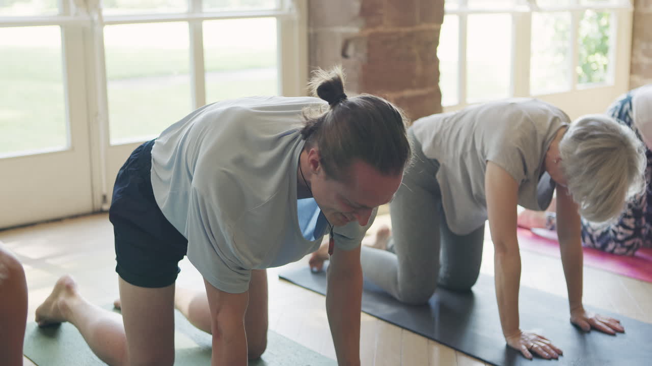 Yoga class with people stretching on mats