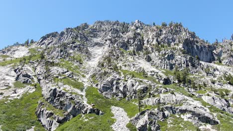 4K-stabilized-drone-shot-of-jagged-mountain-range-with-cliffs-rocks-covered-in-trees-and-nature-in-the-wilderness-of-California,-perfect-for-hiking-and-camping-in-the-summer-with-friends-and-family