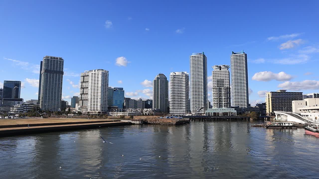 Apartment in front of the waterfront during the day on the sunny day with the seagull flying across.