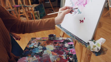 woman painting a flower in an art studio