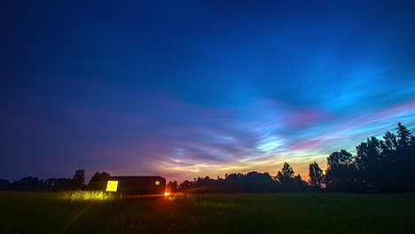 thermowood shed in green field under beautiful and colorful sky - timelapse shot