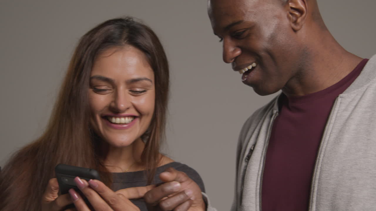 Studio Shot Of Group Of Friends With Mobile Phones Celebrating Winning Money Against Grey Background 3