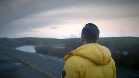 Filmische-Außenlandschaft-Mit-Einem-Mann-In-Gelber-Jacke,-Der-In-Der-Natur-Spaziert