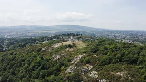 Moving-towards-The-Obelisk-located-in-Killiney-Hill-with-the-view-of-The-Pyramid-of-Dublin-on-a-sunny-day,-Ireland