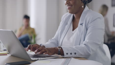 mujer de negocios navegando en una computadora portátil mientras trabaja