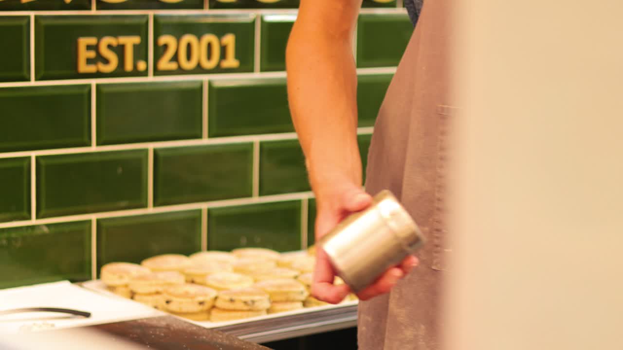 el panadero salpica azúcar en los pasteles galeses