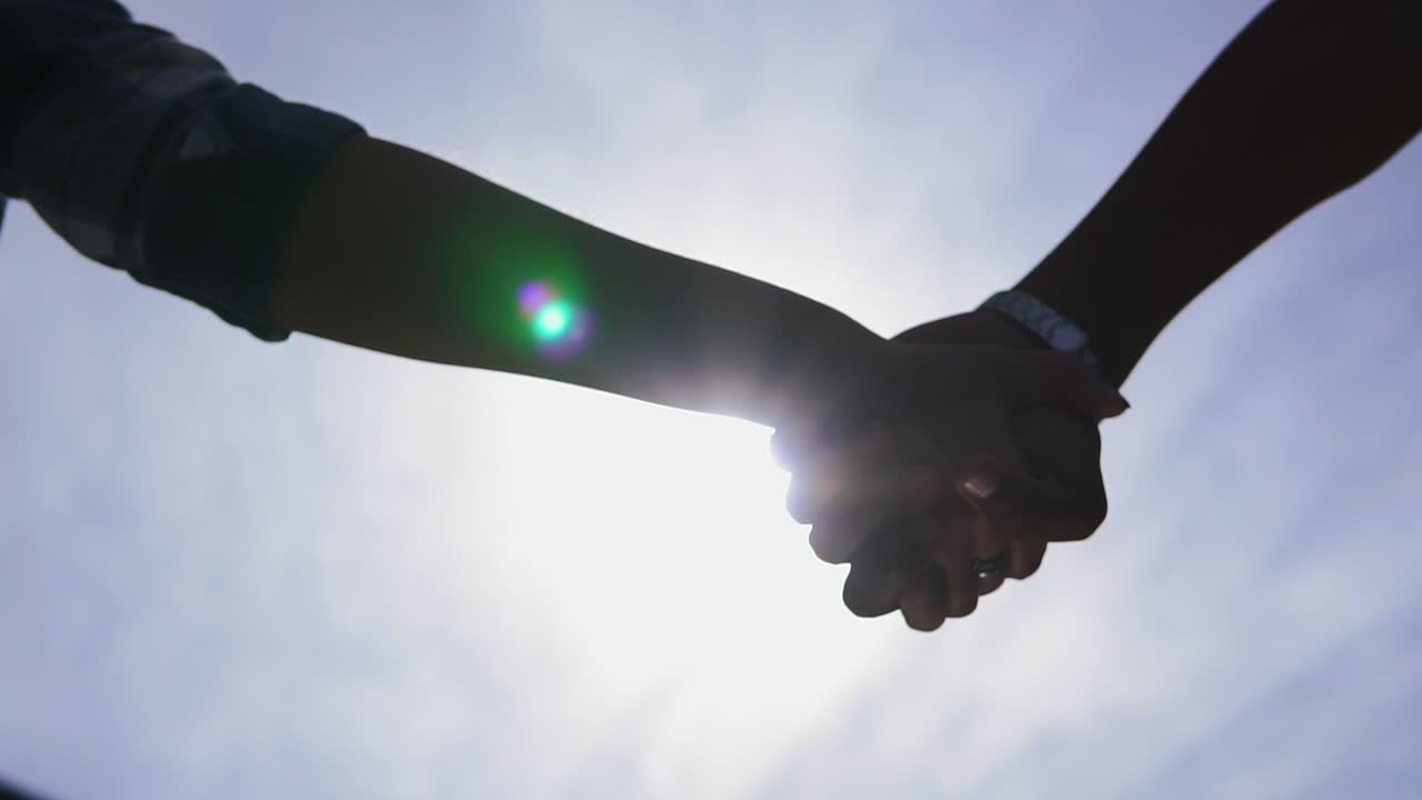 눈에 띄지 않는 로맨틱 한 커플 이 손을 잡고 함께 걸어가기 시작 하는 낮은 각도