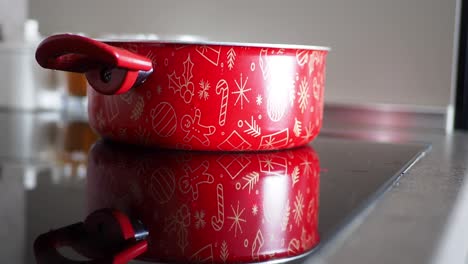 olla roja con tema navideño en la estufa