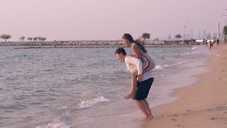 Una-Mujer-Vestida-Salta-Sobre-Su-Novio-En-El-Agua-A-Cámara-Lenta