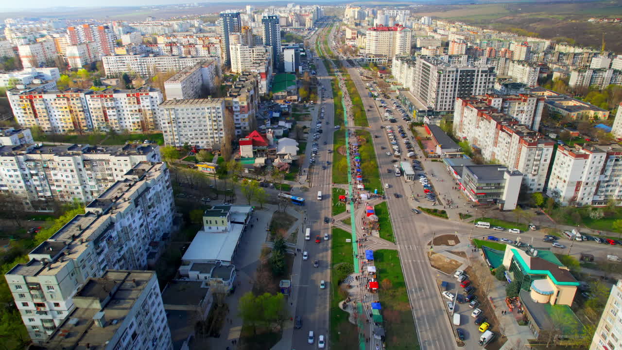 Весенний Кишинев, Молдова, с высоты птичьего полета. Жилой район с множеством квартир, аллея с гуляющими людьми, дорога с движущимися автомобилями