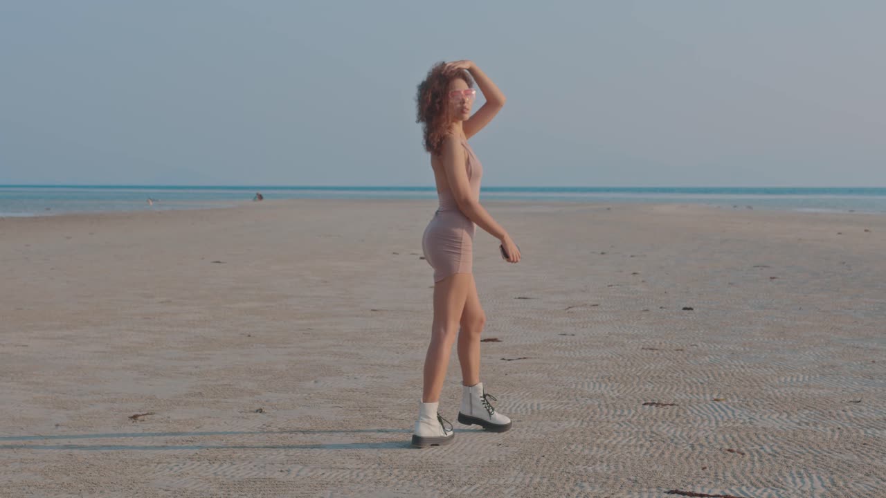 Woman in a dress walking on a beach