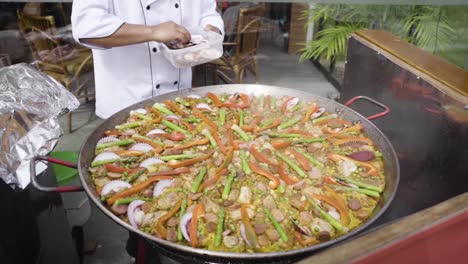 Chef-preparing-a-Spanish-style-Paella-in-Costa-Verde,-Lima,-Peru