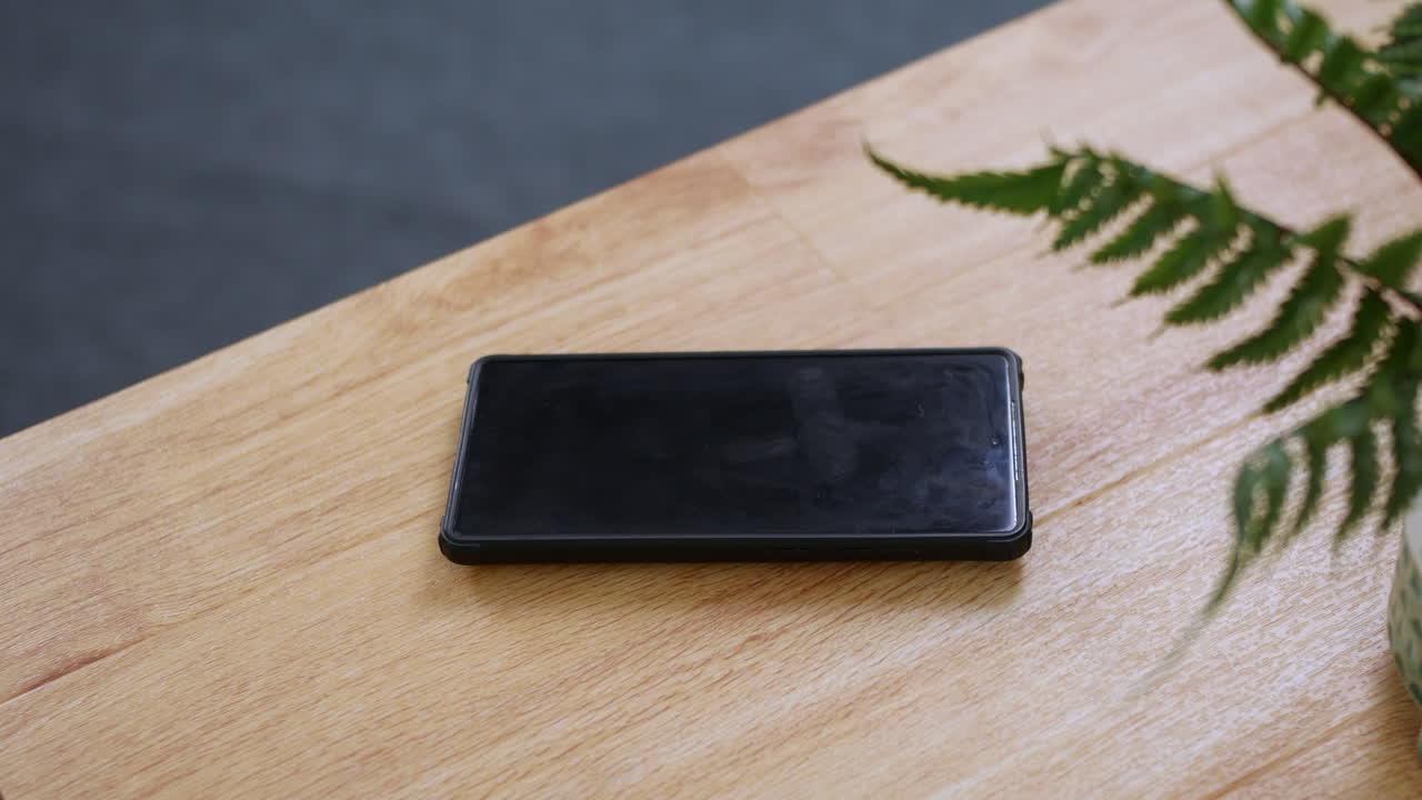 A phone ringing on a wooden desk table | Premium Stock Video Footage