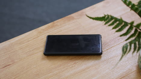 a phone ringing on a wooden desk table