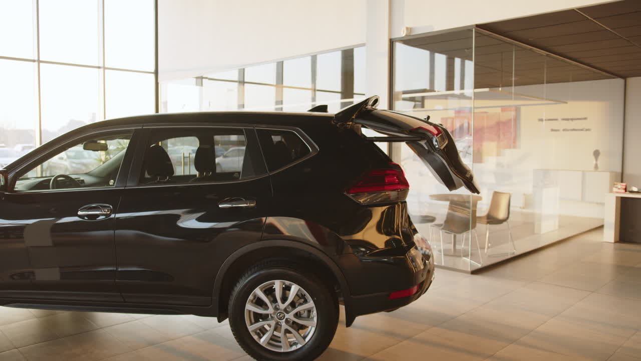 suv negro con maletero abierto en el concesionario de automóviles