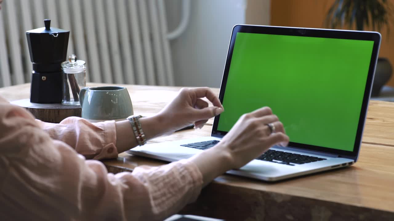 mujer trabajando en una computadora portátil con pantalla verde