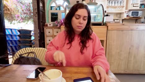 woman using smartphone in restaurant, waiting for order
