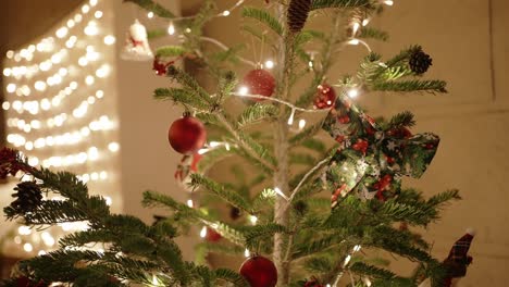 christmas tree with red ornaments, lights, and festive ribbon decoration