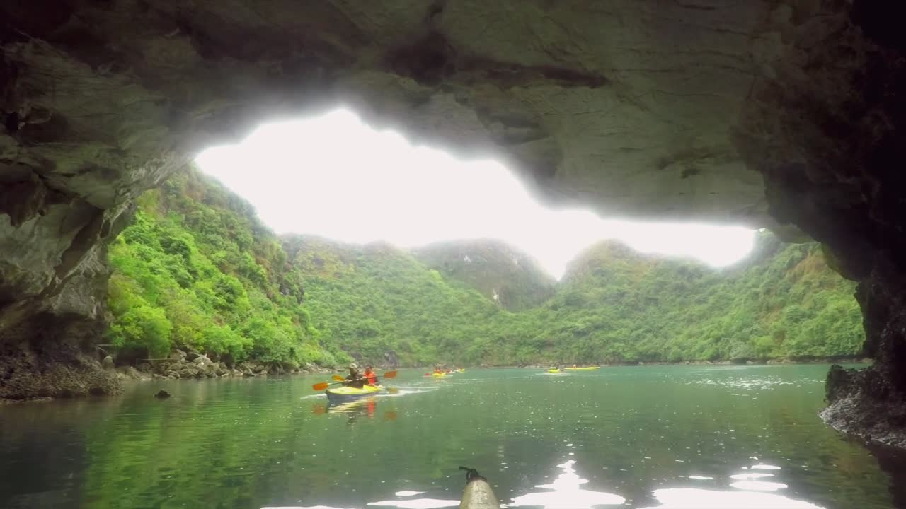 Kayaking Through Cave on a Lake to the View of Green Mountains