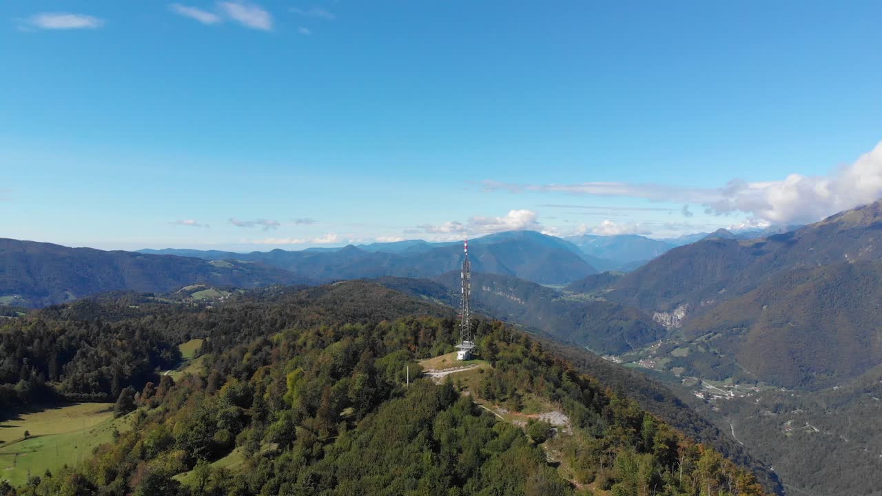 antena de comunicaciones en la cumbre del vasto valle del pico de la montaña verde y exuberante órbita aérea derecha