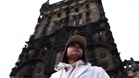 girl stand near impressive gothic style powder gate building exterior