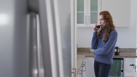 woman drinking coffee in the kitchen at home