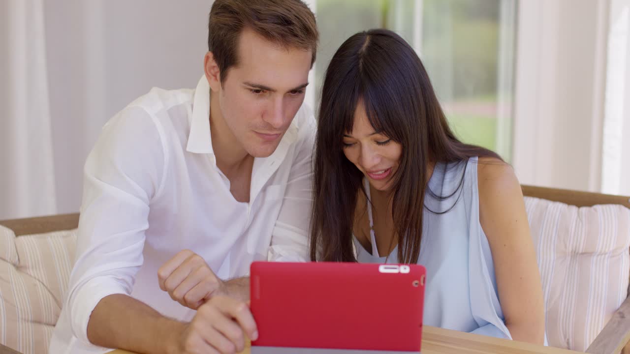 pareja sonrojada mostrando imágenes de ultrasonido