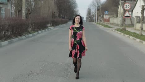 Una-Joven-Atractiva-Con-Un-Vestido-Con-Flores-Caminando-Por-La-Carretera.