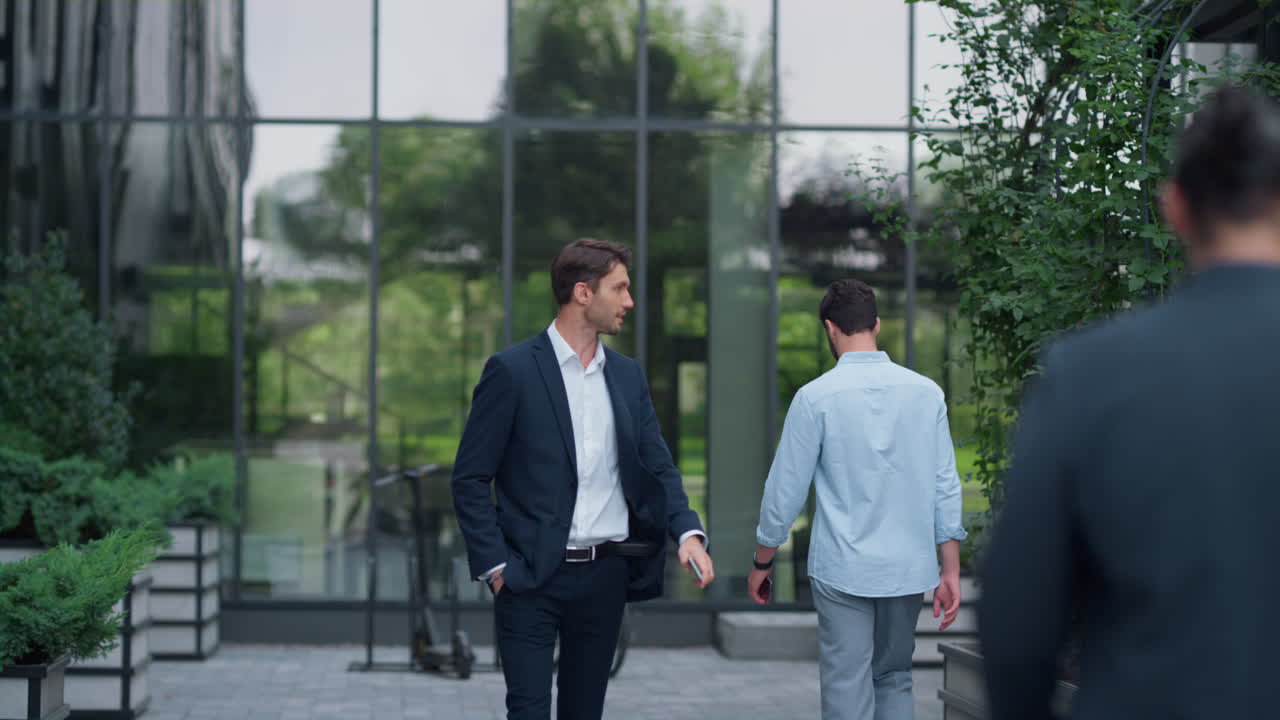 los hombres de negocios confiados van a los edificios de oficinas, las personas corporativas caminan a los lugares de trabajo.