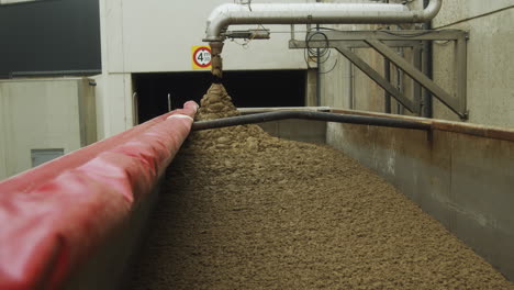 a factory dumping waste into a cargo truck