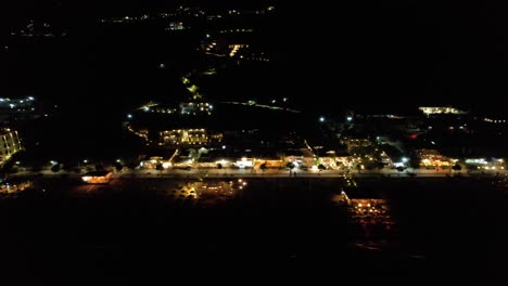 nightlife on famous beach of dhermi in coastline of ionian sea in albania, colorful lights illuminating beach bar with load music, summer vacation in mediterranean