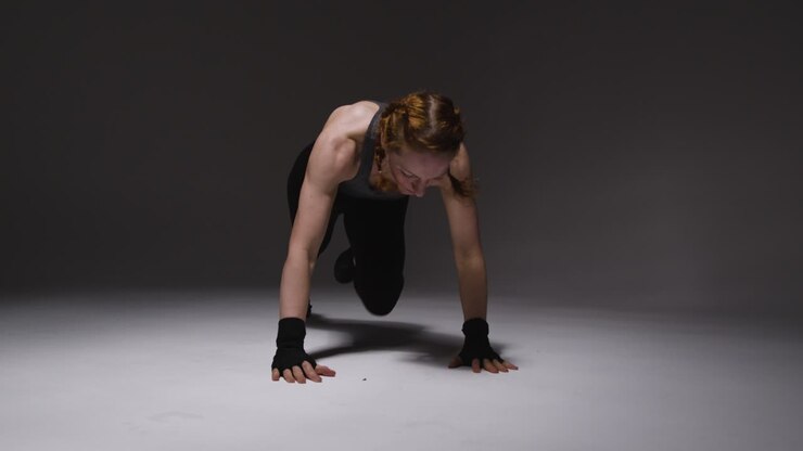 Studio Shot Of Mature Woman Wearing Gym Fitness Clothing Doing Mountain Climber Exercise