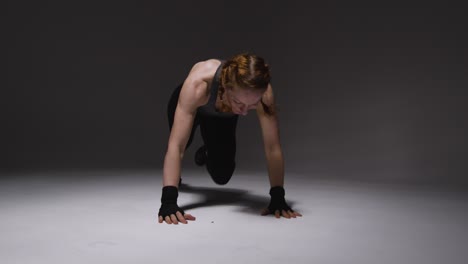 fotografía de estudio de una mujer madura con ropa de gimnasia haciendo ejercicio de escalador de montaña