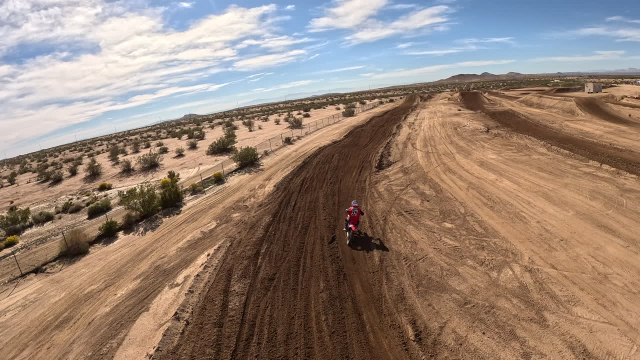 siguiendo a un motociclista mientras corre por una tachuela y salta en un dron en primera persona