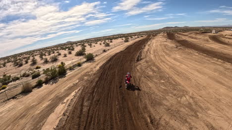 Following-a-motorcyclist-as-he-races-down-a-tack-and-jumps-in-a-first-person-drone