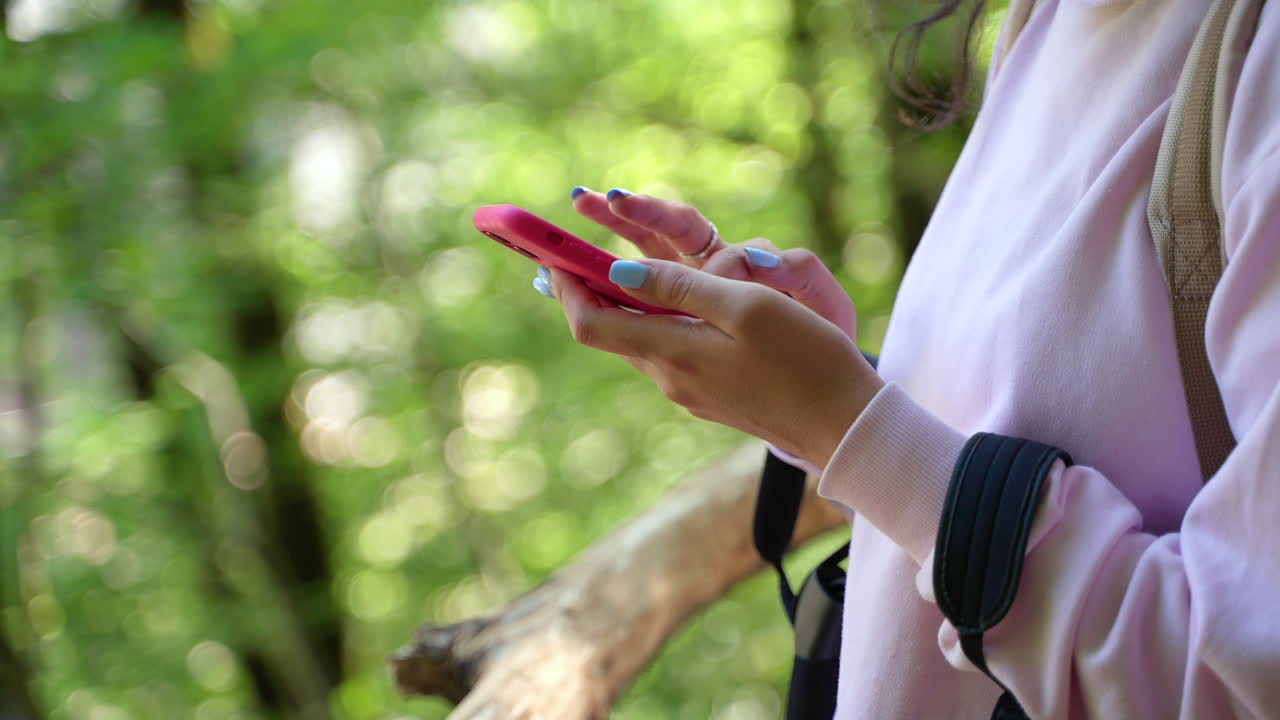 mujer usando el teléfono en un bosque