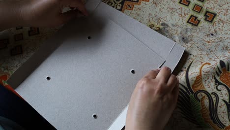 woman's hand folds a paper lunch box