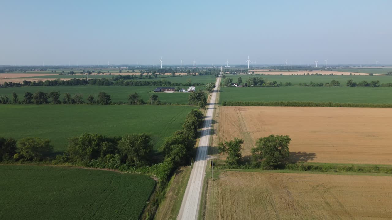 flying in quiet farmland showing renewable wind energy turbines canada