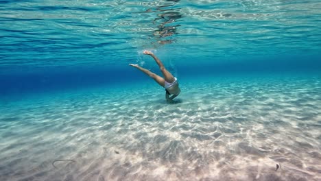 Escena-Submarina-De-Una-Niña-Nadando-Y-Divirtiéndose-Inmersa-En-Agua-De-Mar-Tropical-Prístina-Y-Fresca-De-Una-Isla-Exótica