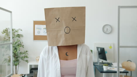woman with paper bag over her head in office