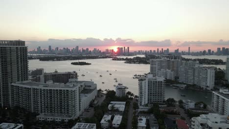 Vista-Aérea-De-South-Beach-Sunset-Con-El-Centro-De-Miami-Más-Allá-De-Biscayne-Bay